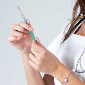 Doctor woman with syringe isolated on white , nurse with needle.