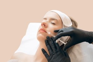 Woman giving botox injections. Young woman gets beauty facial injections in the cosmetology salon. Face aging injection. Aesthetic Medicine, Cosmetology