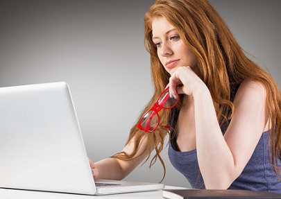 Young woman sitting at desk using laptop 
