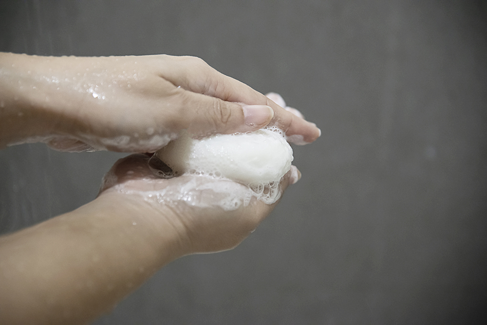 Lady hands with soap in a bath room - clean health care concept