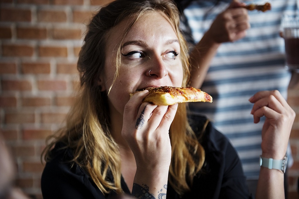 Female eating greasy pizza comfort food